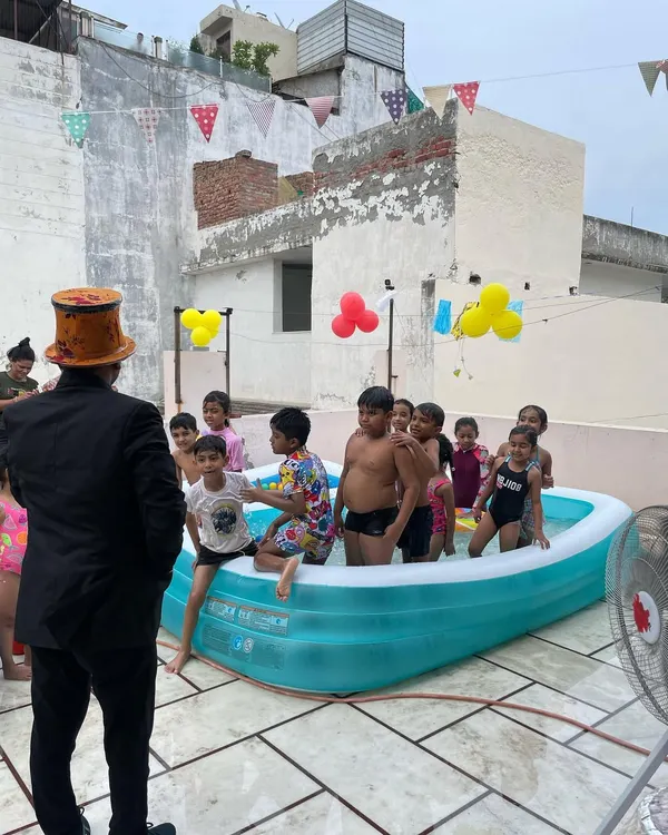 Organizing a fun pool party on a rooftop. I'm here as the magician, ready to perform some water-themed tricks for the kids.