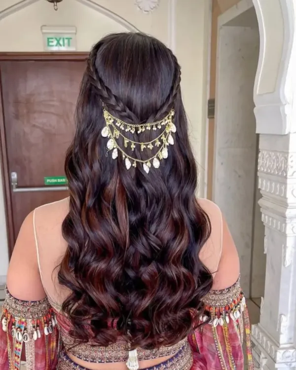 Hair that speaks royalty. This intricate, wavy half-up style with a beautiful hair accessory is perfect for a bride or for any grand celebration.