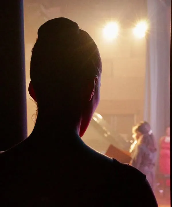 The moment just before stepping on stage. Standing in the wings, heart racing, every muscle ready. This is the quiet anticipation before the performance begins.
