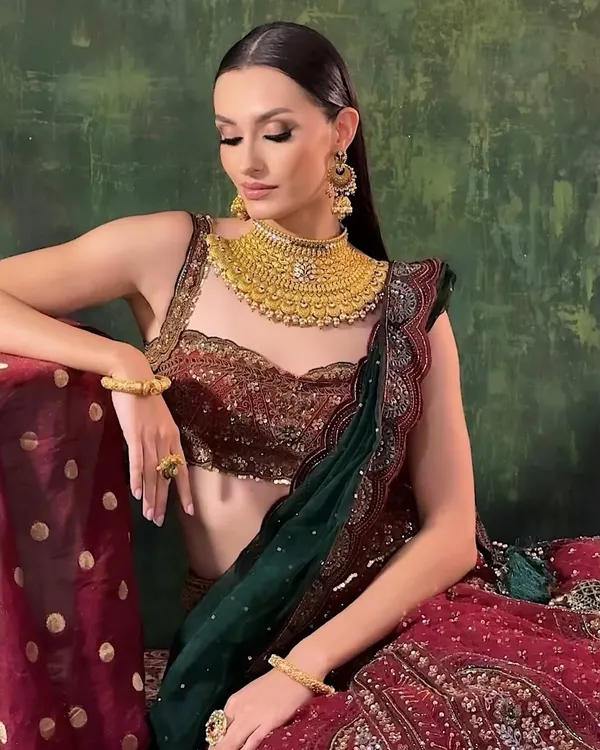 A stunning campaign shot featuring a modern take on a traditional look. The makeup is clean and sharp, with a focus on sculpted features and flawless skin.