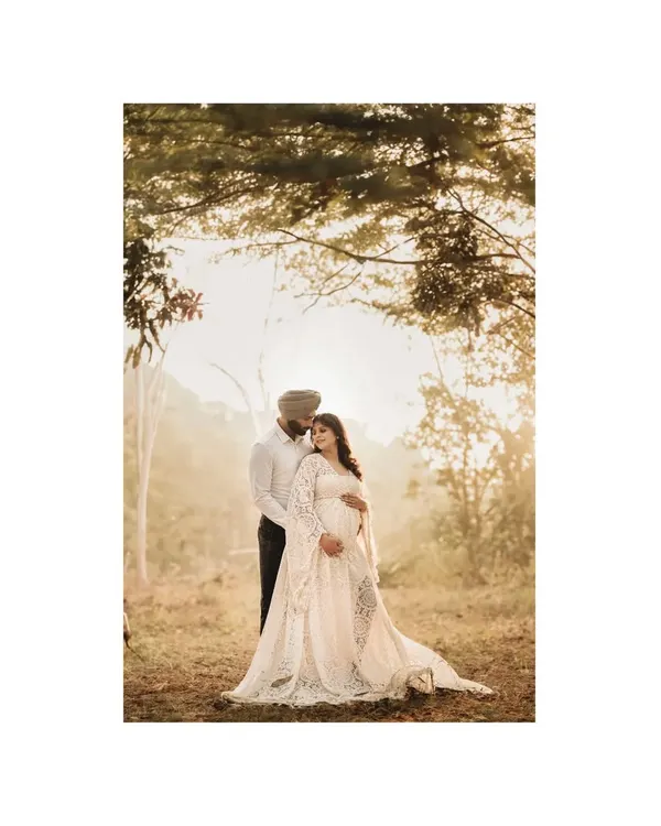 In the magical light of a forest at sunset, an expecting couple shares a quiet, intimate moment. This outdoor maternity photoshoot captures the deep affection and anticipation of their journey into parenthood.