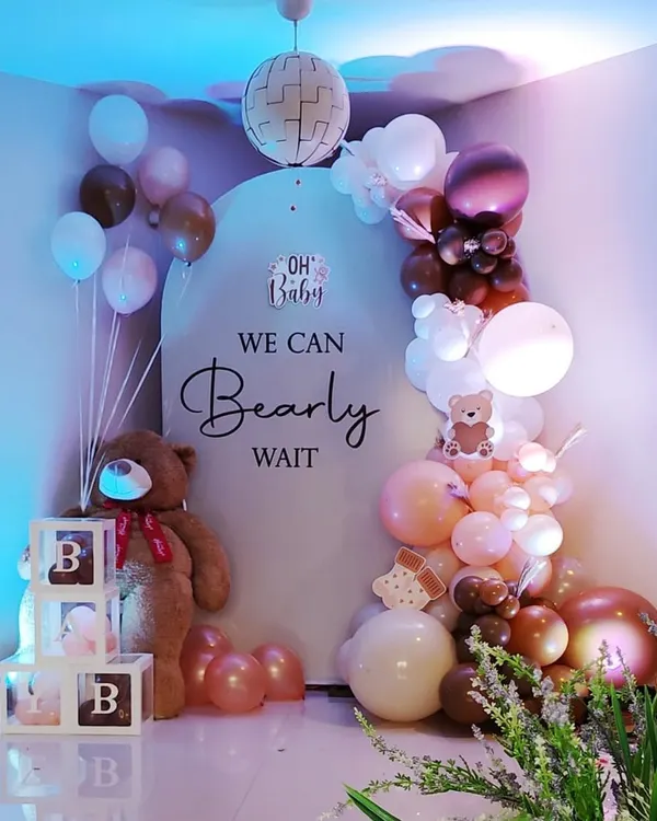 A classic "We Can Bearly Wait" baby shower theme. This cozy setup includes a giant teddy bear, custom backdrop, and a beautiful balloon arrangement in brown, pink, and white tones.
