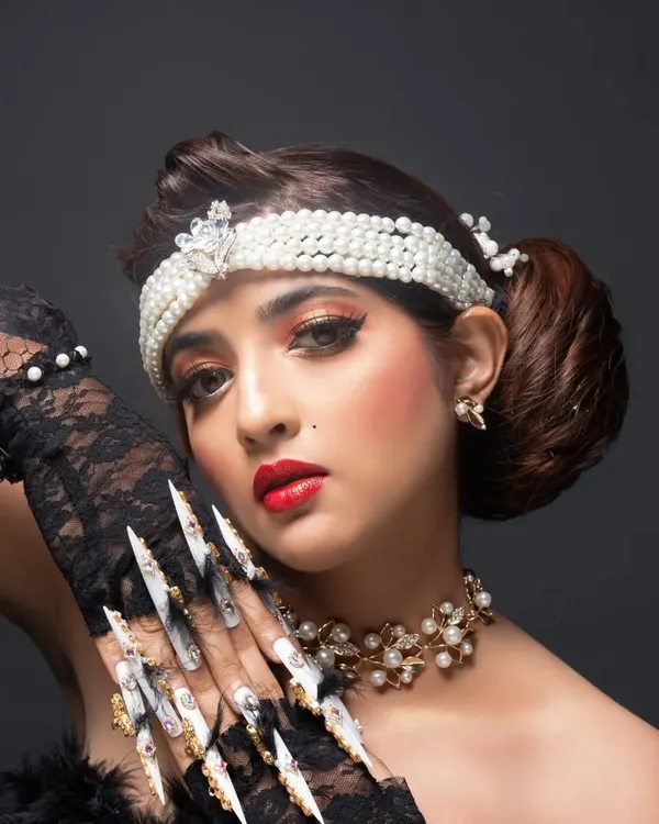 A look at the fantasy nail art I created for a makeup artist's beauty competition. The retro look included these extra-long stiletto nails with heavy jewelry and feather accents.