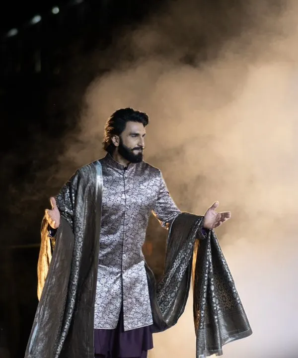 Ranveer Singh owning the stage for Manish Malhotra's 'Dharohar Kashi Ki' show in Varanasi. A dramatic shot capturing his powerful presence amidst smoke and stage lights.