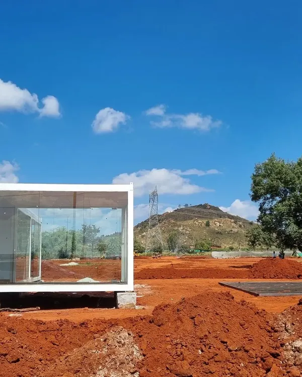 The very beginning of a new project. This minimalist glass structure is placed on the raw red earth, a blank canvas upon which a holistic masterplan for ecological and landscape design will unfold.