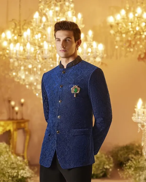 A royal blue textured bandhgala jacket styled for a Louis Philippe campaign. The look is elevated with a jeweled brooch, creating a regal and sophisticated ensemble perfect for a wedding or formal event.