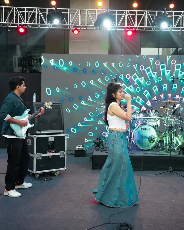 Performing on a large, professionally lit stage with my guitarist. This wide shot shows our duo setup for a concert, complete with a large LED screen backdrop.