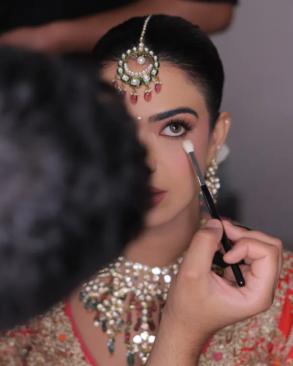 The art is in the details. A behind-the-scenes shot capturing the precise application of eyeshadow. Every brushstroke is intentional, aimed at creating a look that is perfect for the bride.
