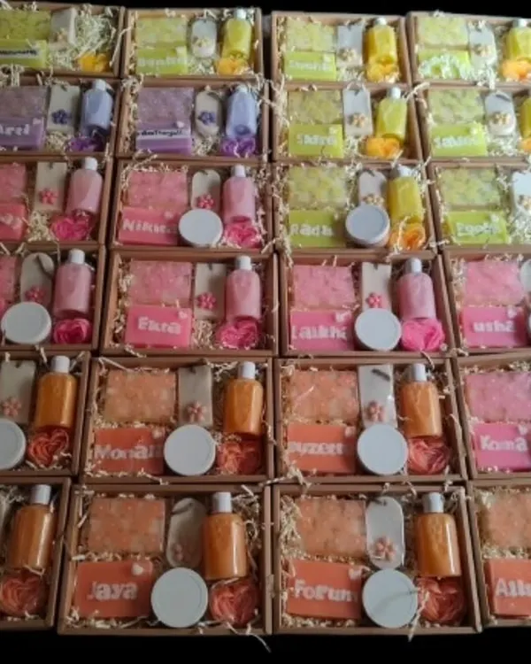 A large corporate order ready for dispatch. Each box is personalized with a name and contains a custom set of handmade soaps, candles, and body wash.
