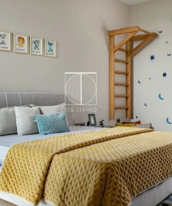 This kids' room is designed for imagination and play. We built the custom bed with a soft, channel-tufted headboard, the playful wall ladder, and the star and moon wall decals to create a magical space.