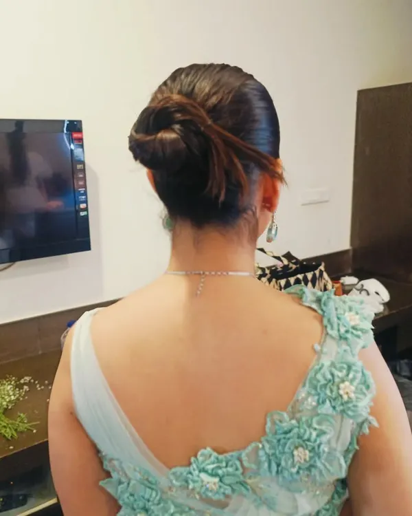 A modern and chic textured bun with a few loose strands to frame the face. This updo is perfect for a cocktail party or reception, pairing beautifully with an elegant gown.