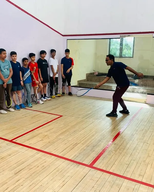 We believe in leading by example. Here, I am demonstrating the correct forehand swing technique to a group of young, attentive players. Our group sessions are structured to ensure every student understands the core mechanics of the game.