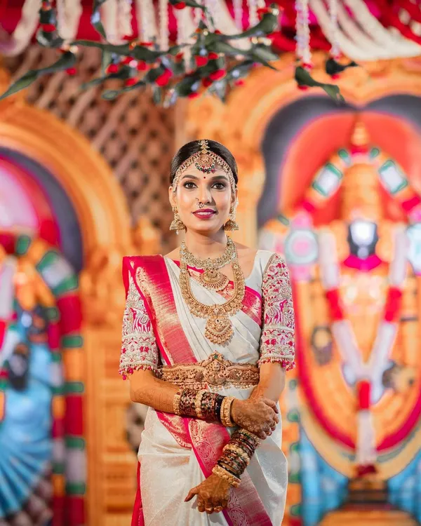 This is the quintessential South Indian bridal look I love to create. For this bride's Muhurtham, we chose a flawless base that lasts through all the ceremonies, paired with classic eye makeup and a bold lip to complement her stunning white and pink Kanchipuram saree.