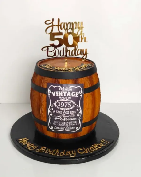 Aged to perfection. This cake is sculpted to look like a vintage whiskey barrel, complete with wood grain texture and a personalized "Vintage" label, celebrating a 50th birthday in style.