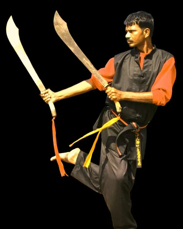 A student demonstrates a dynamic pose with dual butterfly swords. This advanced weapon requires immense coordination, balance, and skill to master.