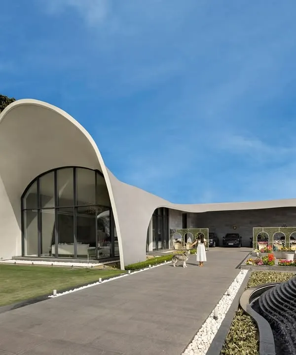 This is the hero item. We designed this modern fluidic outhouse in Punjab as a space for premier entertainment. Its signature architectural feature is a gracefully curved roof that recreates the form of a rising wave, creating a structure that is both a building and a sculpture.