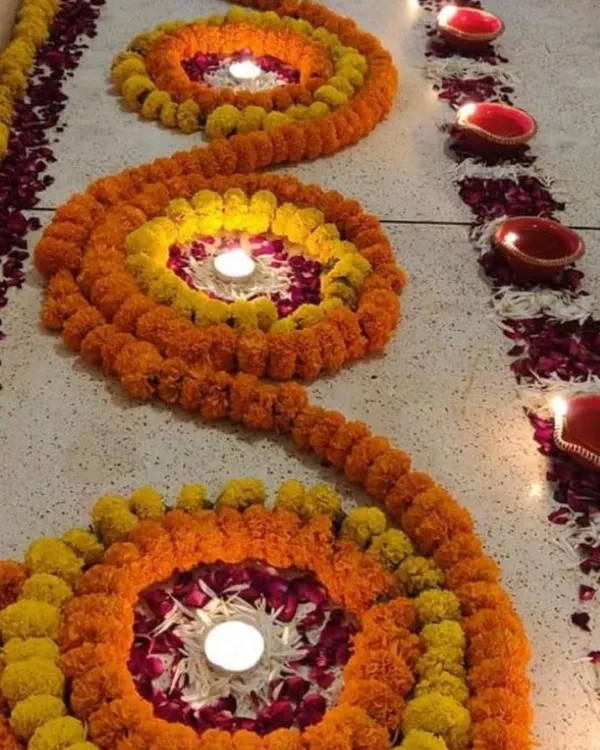 This is a floral rangoli I made using marigold strings to create spiral patterns. I placed diyas in the center of each spiral and scattered rose petals to complete this traditional floor decoration.