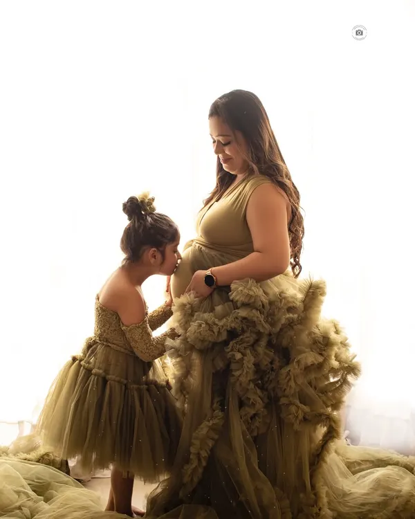A truly precious moment of an older sister kissing her mother's baby bump. These are the memories that families will cherish forever.