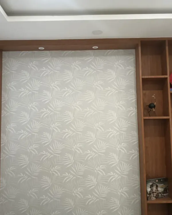 A subtle leaf-patterned wallpaper installed in a TV unit niche.