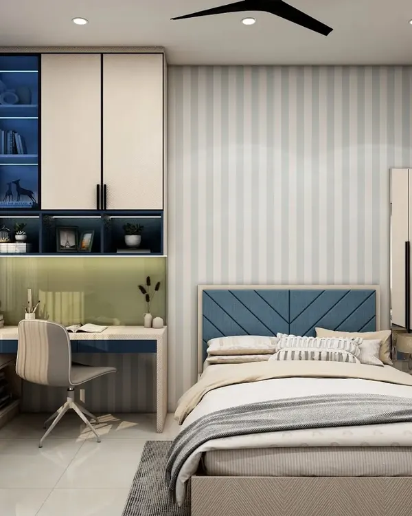 A perfect room for a growing child, this space features a built-in study desk with overhead storage and a cozy bed. The blue and white color scheme with striped wallpaper creates a classic, timeless look.