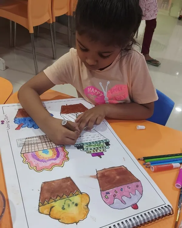 Our cupcake project is a super fun way to learn about texture. Here, a student is carefully coloring her designs before adding collage materials.