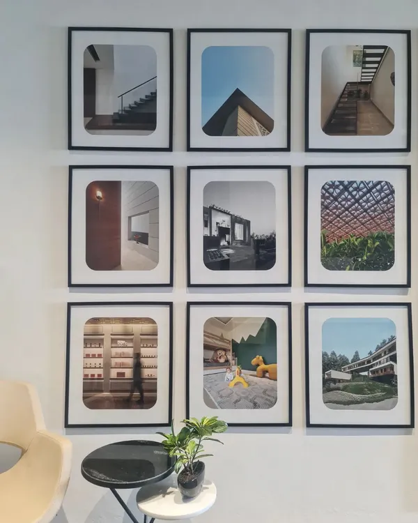 A glimpse of life in our studio, with a gallery wall displaying photographs of our diverse projects. This wall serves as a constant source of inspiration and a testament to the architectural stories we have created.