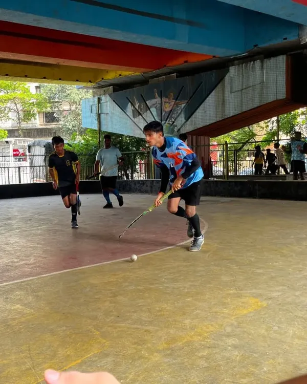 A junior player dribbles the ball down the court during a fast-paced rink hockey session. Our practices focus on quick thinking and sharp stick skills.