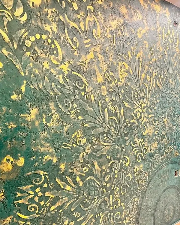 This is a close-up of a highly detailed embossed texture in a rich green and gold palette. This custom finish creates a dramatic, three-dimensional effect that is perfect for a luxurious and opulent feature wall.