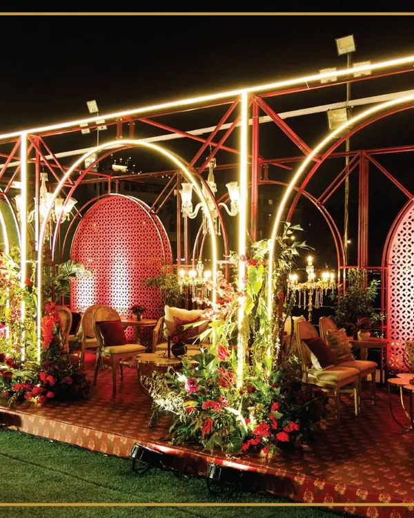 An enchanting evening setup featuring glowing arches and lush floral arrangements. We design every detail to create a magical atmosphere for your grand celebration.