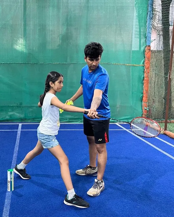 Perfecting the grip is the first step to a powerful game. Our coach provides hands on instruction to a young student, ensuring she learns the correct badminton grip technique for better control and shot accuracy.