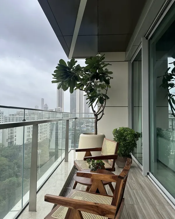 This balcony is an urban retreat, featuring my custom-designed mid-century modern chairs in wood and cane. The design provides a comfortable and stylish outdoor seating area that seamlessly merges with the city skyline.