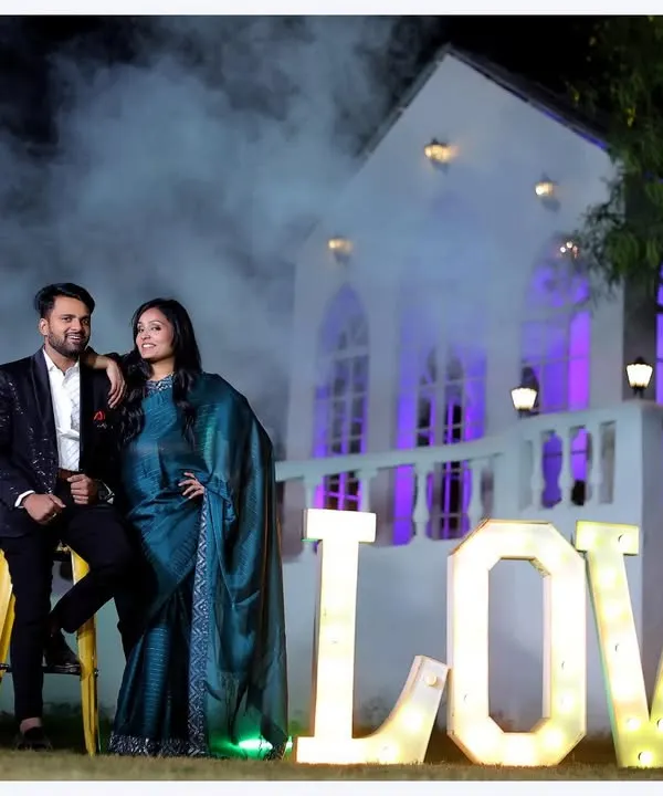 Our stunning white chapel backdrop creates a magical, romantic setting for pre-wedding photoshoots, especially during the evening. We use dramatic lighting and props like these illuminated 'LOVE' letters to make your couple portraits truly unforgettable.