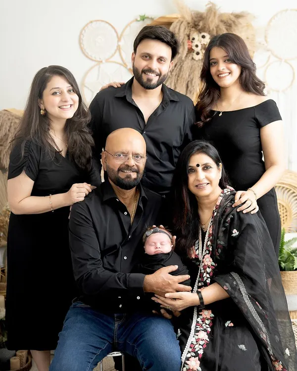 A beautiful multi-generational family portrait. The grandparents hold their newborn grandchild, surrounded by the love of their children and other grandchildren. This is a true family heirloom.