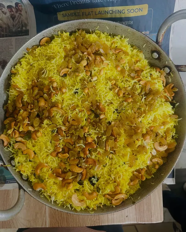 Our flavorful Lemon Rice, garnished with fried cashews and raisins. It's a tangy and delicious part of our South Indian combo.