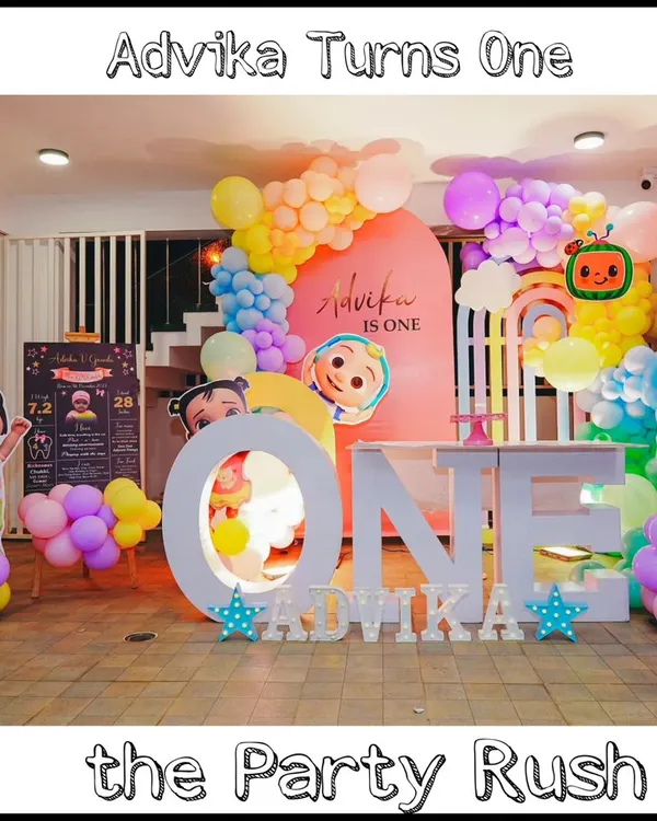 This Cocomelon party for Advika's first birthday is a perfect example of a complete and immersive theme. It features character cutouts, a personalized backdrop, a large 'ONE' prop for photos, and a beautiful pastel rainbow balloon arch.