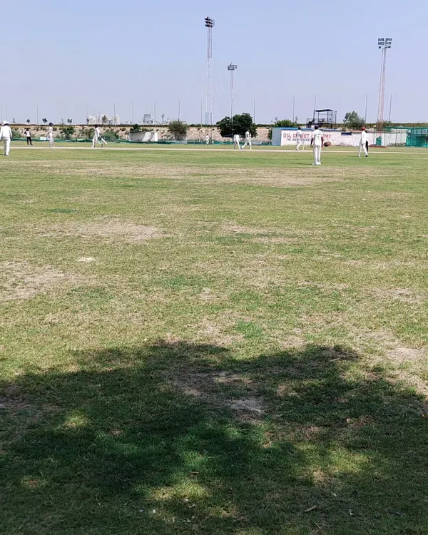 A view of our main cricket ground during a weekly practice match. We have a lush, well-maintained grass field to ensure you get experience in real match conditions, which is a core part of our residential program.