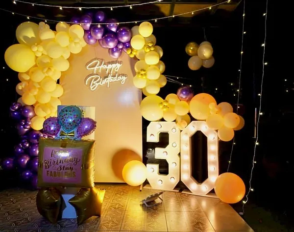 Go big for the 30th! This birthday bash featured a statement photo corner with a large balloon arch, a 'Happy Birthday' neon sign, and illuminated marquee numbers for the big 3-0.