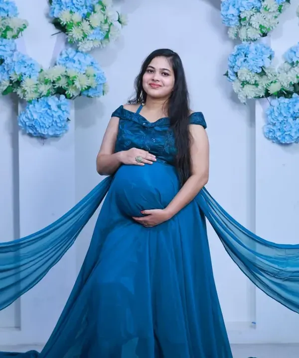 A classic maternity portrait in my studio. The flowing blue gown and floral backdrop create a serene and beautiful setting to celebrate your pregnancy.