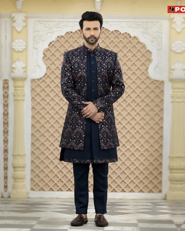 This dark navy Jodhpuri suit is a great example of modern royal attire. The jacket features a subtle, intricate print over a solid navy kurta, creating a sophisticated look for any evening celebration.
