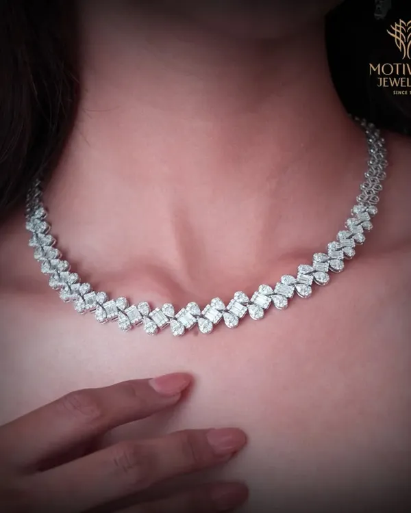 A breathtaking diamond necklace designed with an intricate, leaf-like pattern. This piece sits beautifully on the collarbone, offering a statement of pure, classic elegance.