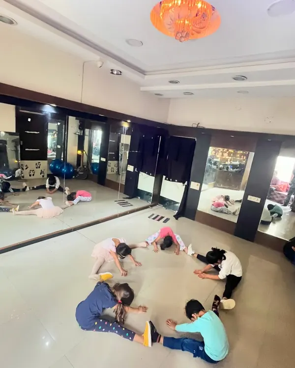 Young students in my Kolkata dance class work on their forward folds and group stretches. We always start with a proper warm-up to build flexibility and prevent injuries.