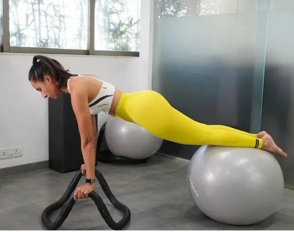 Exercise isn't just about looking good, it's about feeling your best. Here, a client demonstrates a challenging plank on a stability ball, an exercise you can do with minimal equipment.