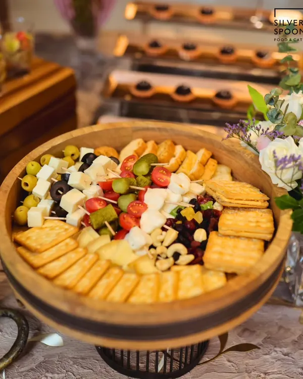 A closer look at our classic cheese platter, featuring a variety of hard and soft cheeses, crackers, nuts, and olives. This setup is perfect for corporate events and intimate birthday parties.