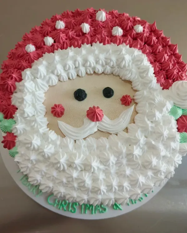 This cheerful Santa Claus cake is one of my favorite Christmas designs to make. I use buttercream frosting to create his fluffy beard and hat, making it a fun and delicious centerpiece for any holiday party.