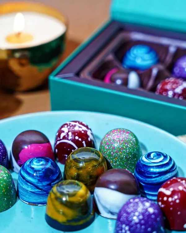 A close-up shot of artisanal bonbon chocolates, highlighting their vibrant colors and intricate designs. This kind of detailed food photography is perfect for luxury confectionary brands looking to showcase the quality of their products.