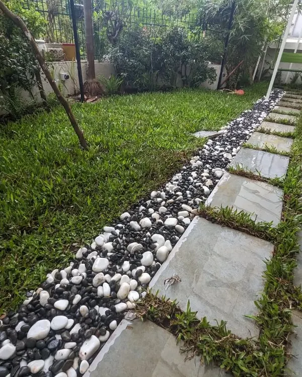 This is what we love to do, turn a simple patch of land into a serene and functional outdoor living space. For this residential project in Thane, we designed and installed a lush lawn alongside a clean stone pathway, bordered with contrasting pebbles for a modern look.