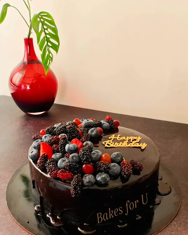 A rich, decadent chocolate cake with a glossy ganache finish. I topped this one with a beautiful assortment of fresh berries, including blueberries and mulberries, for a perfect balance of sweet and tart flavors.