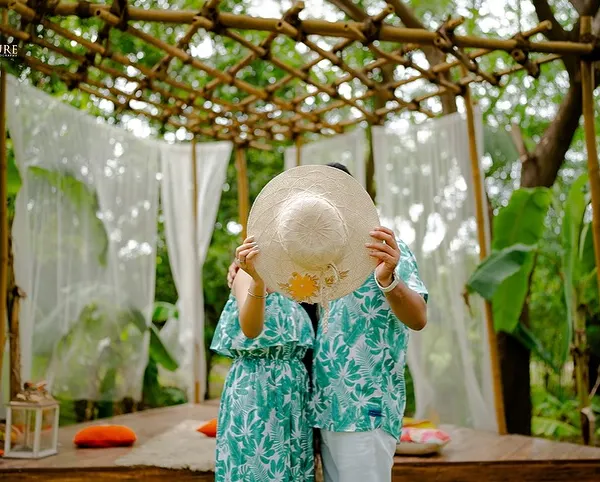 A playful and cute moment where the couple hides behind a sun hat. This shot, taken at our Bali-themed set in Mumbai, is fun, candid, and perfect for a save-the-date.