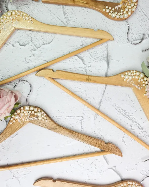 The perfect shot starts with the perfect hanger. We create these beautiful wooden hangers, personalized with names and embellished with pearls, for your wedding dress and bridesmaid gowns.