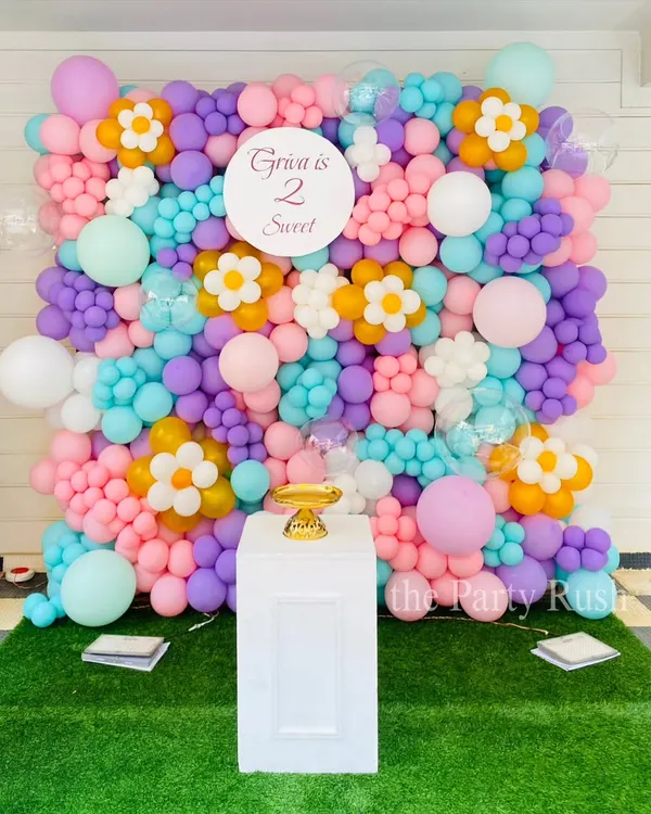 This "Two Sweet" balloon wall I created for Griva's second birthday is a perfect example of a custom photo backdrop. The pastel-colored balloons are arranged with daisy flower accents to create a beautiful and fun floral garden effect.